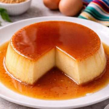 Mexican caramel flan with a slice removed, showing smooth custard texture and glossy caramel sauce