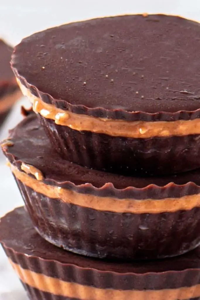 Close-up of no-bake peanut butter cups showing the rich dark chocolate and smooth, salty-sweet peanut butter layer.