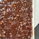 Close-up of moist chocolate Texas Sheet Cake topped with warm cocoa pecan glaze