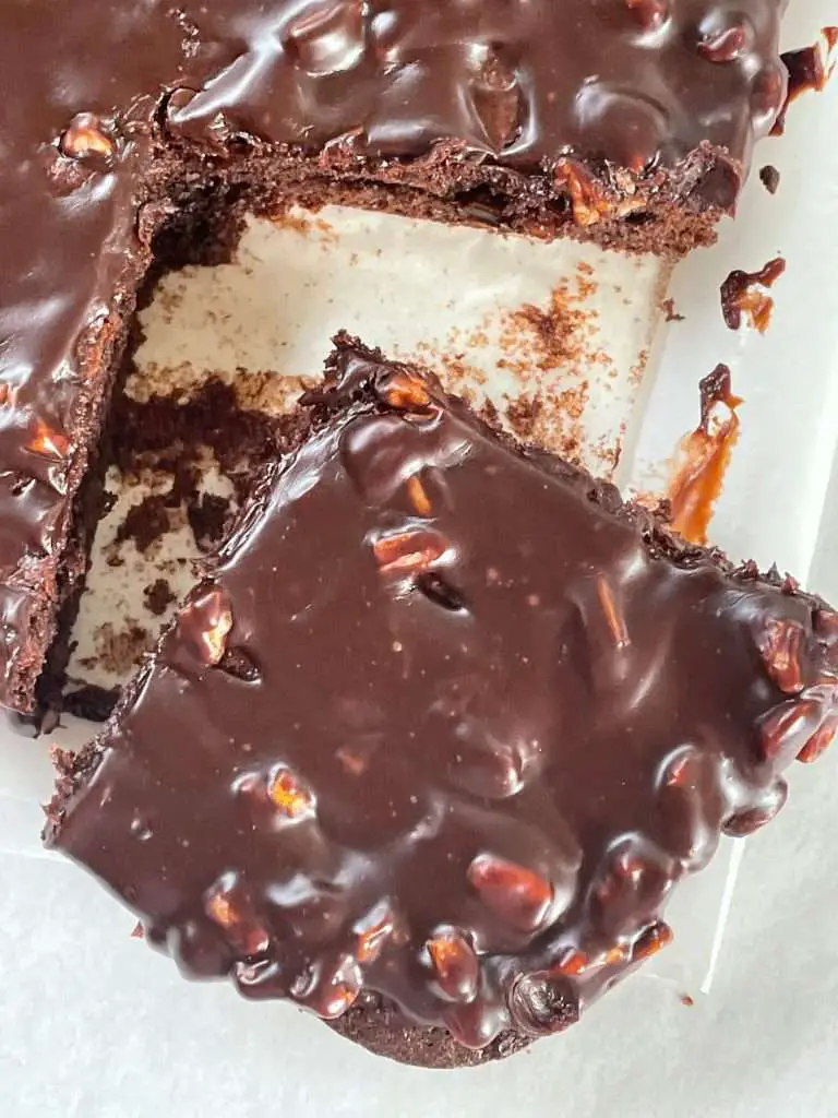 Fudgy Texas Sheet Cake with cocoa pecan glaze, sliced from the corner.