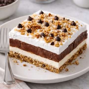 midnight cowboy delight chocolate delight dessert square on a plate showing layered crust cream cheese chocolate pudding and whipped topping