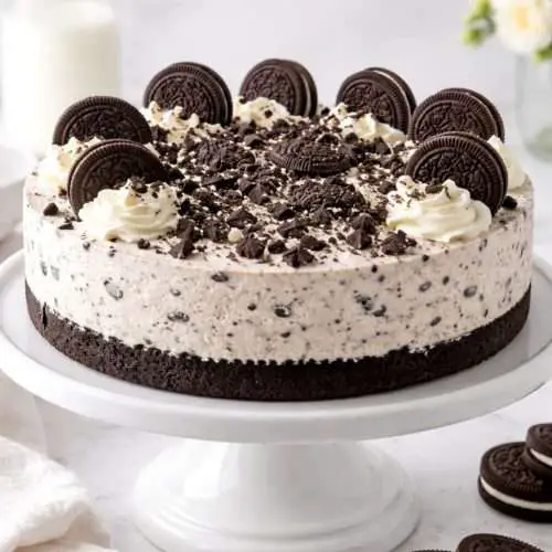 no-bake Oreo cheesecake on a cake stand with Oreo crust and cookies and cream filling topped with Oreos